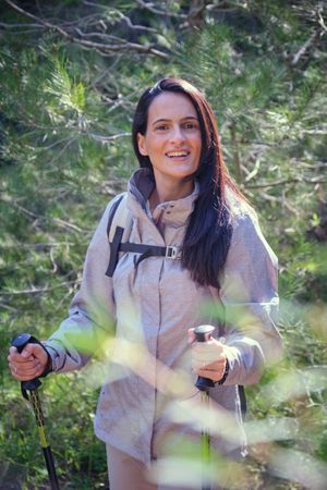 Delighted Hispanic female hiker in woods