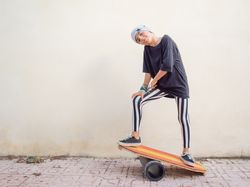 Cheeky boy standing on colorful board and swinging