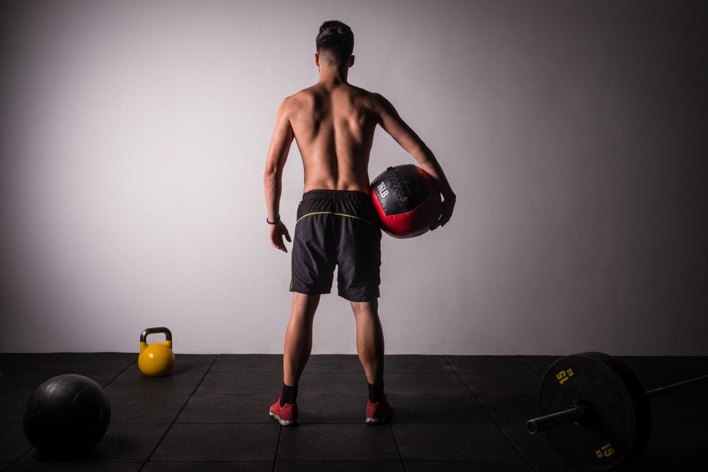 Man throwing ball on wall in gym