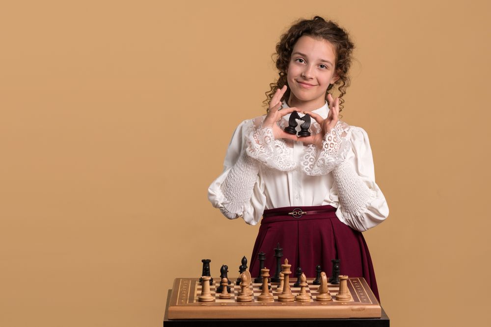 Young girl holding two chess knights
