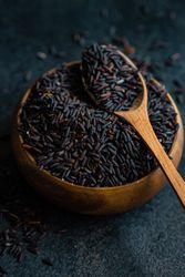 Organic dark rice in bowl with spoon