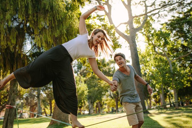 Woman practices slacklining in a park