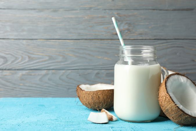 Coconut and milk on blue background, space for text