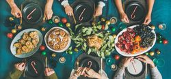 Christmas or New Year party dinner at festive table top view, wide composition