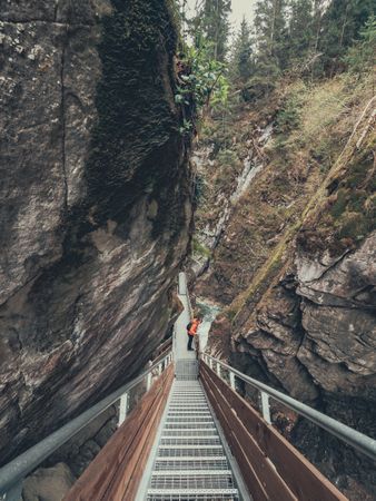 Tourist on hiking path among rocky slopes