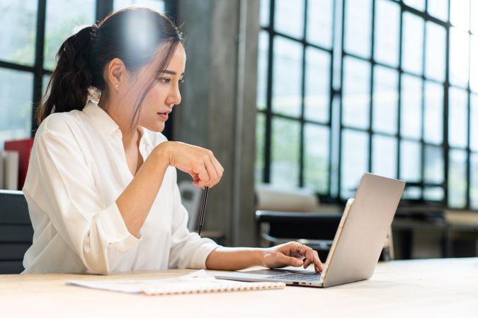 Female reading from laptop in office