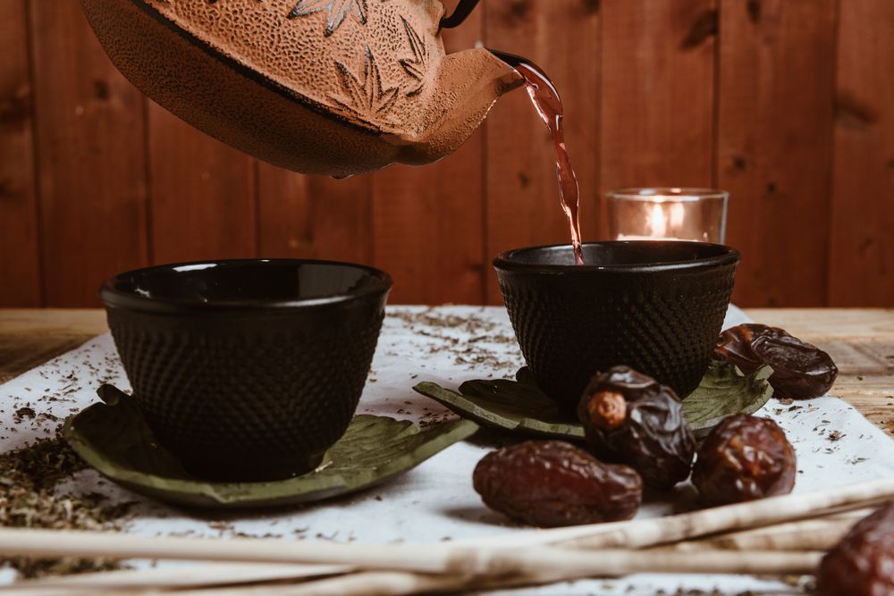 Aromatic tea dates and clay teapot on table