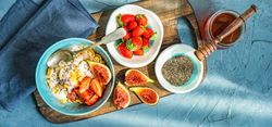 Top view of traditionally healthy breakfast with chia, honey, figs and strawberry on board