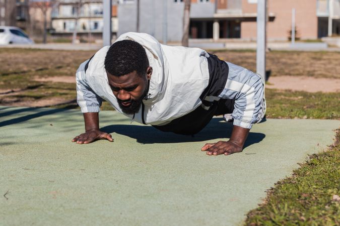 Determined Black sportsman working out in city