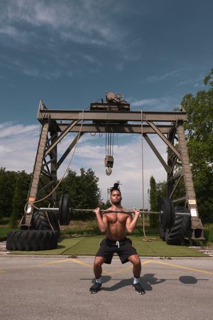 Black guy with barbell in outdoor gym