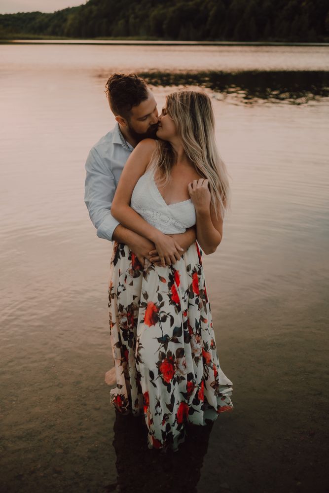 Loving couple hugging while standing ankle deep in water on beach