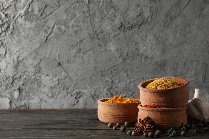 Wooden bowls stacks full of spices with copy space