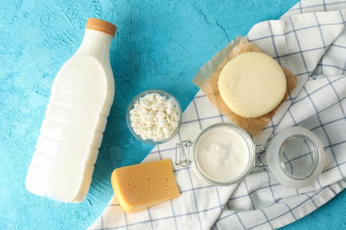 Flat lay composition with fresh dairy products and towel on blue background