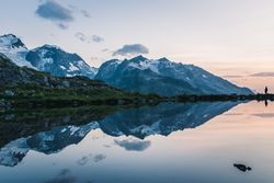 Silhouette standing crystal lake reflecting cloudy sky