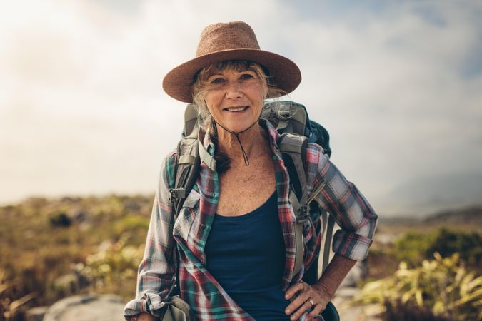 Close up of a smiling woman standing outdoors on a hiking trip