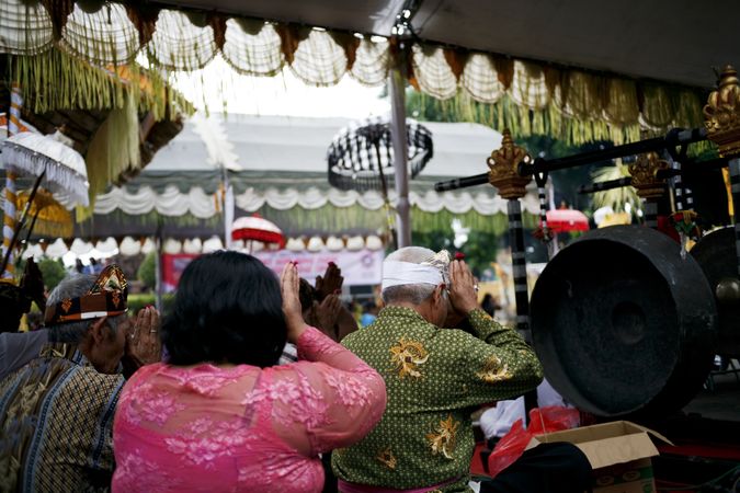 Backs of Indonesian people in Hindu prayer