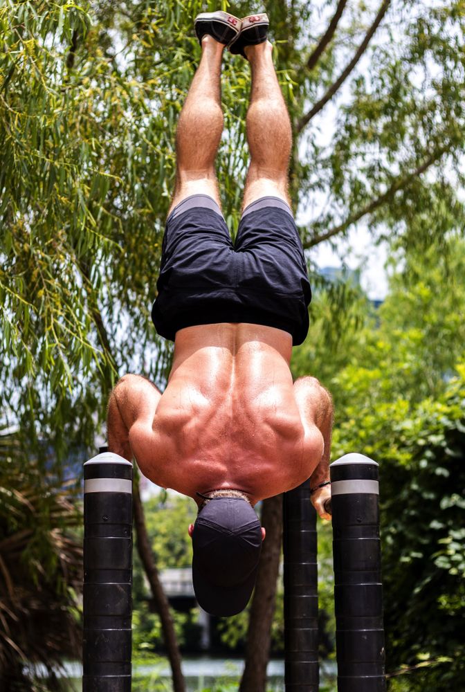 Man doing inversion push-ups outdoor