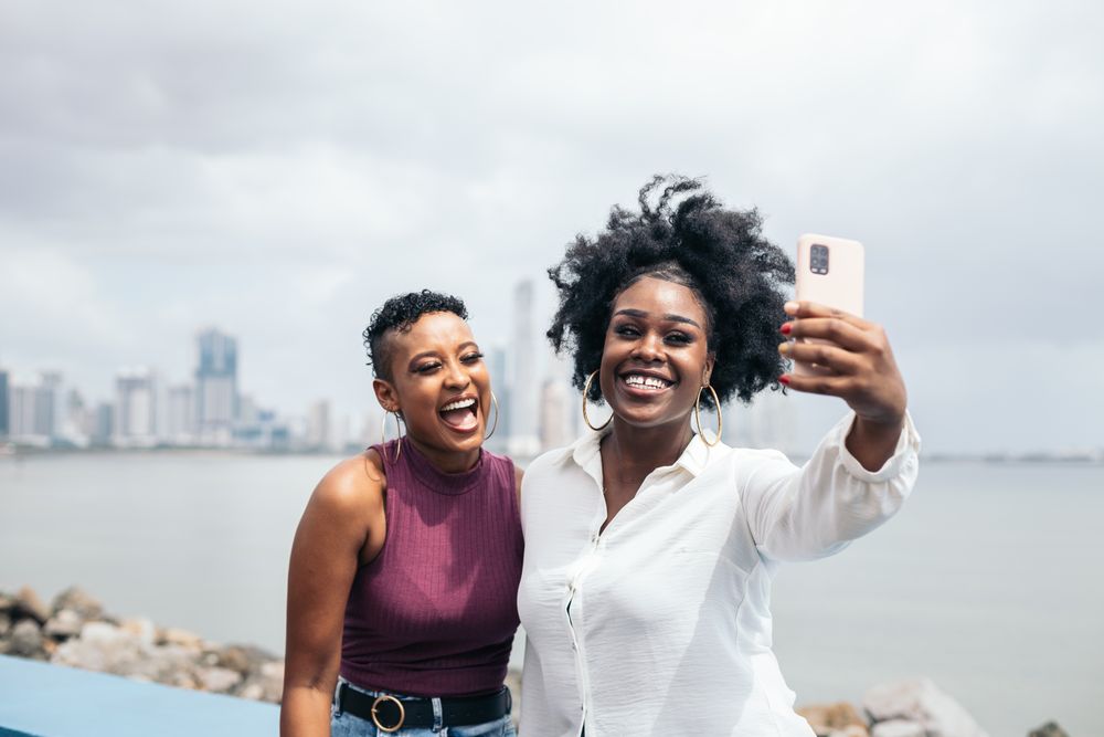 Stylish friends taking selfies along the boardwalk in Panama City