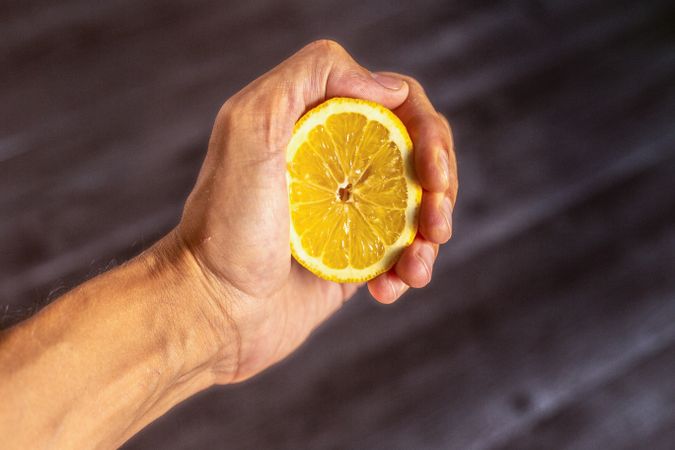 Crop hand with fresh lemon