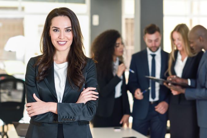 Female business leader standing in front of her colleagues in office