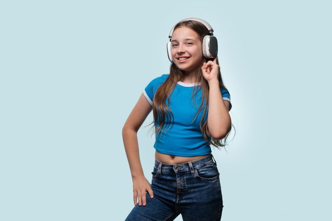 Girl with long hair smiling while wearing headphones.