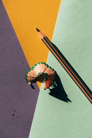 Pencil and shavings from sharpening, on colored papers background