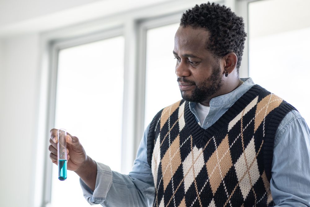 Man holding blue liquid in test tube
