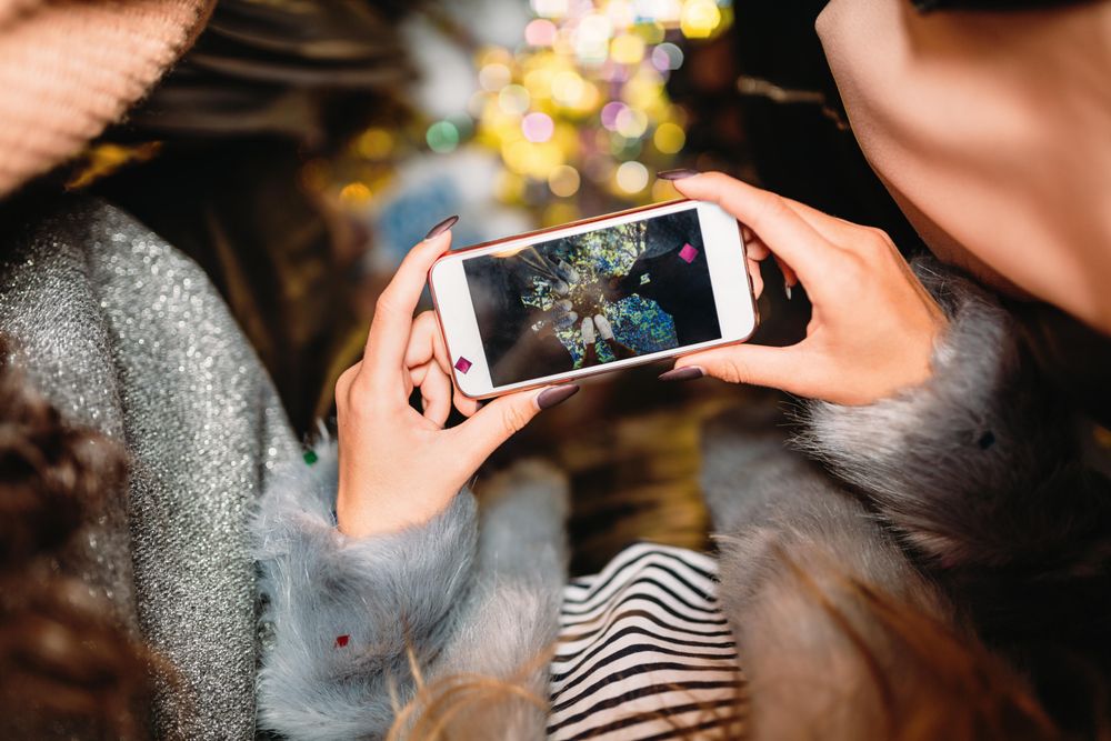 Stylish woman holding a a smart phone at night