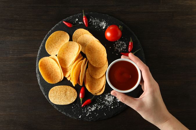 Potato chips in a bowl with chili pepper and sauce