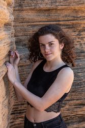 Young female leaning on sandstone rock