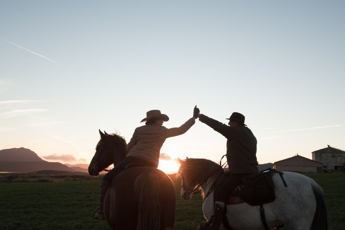 People on horses giving high five