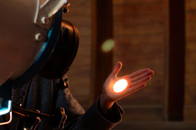 Man’s hand illuminated by focused telescope light beam.