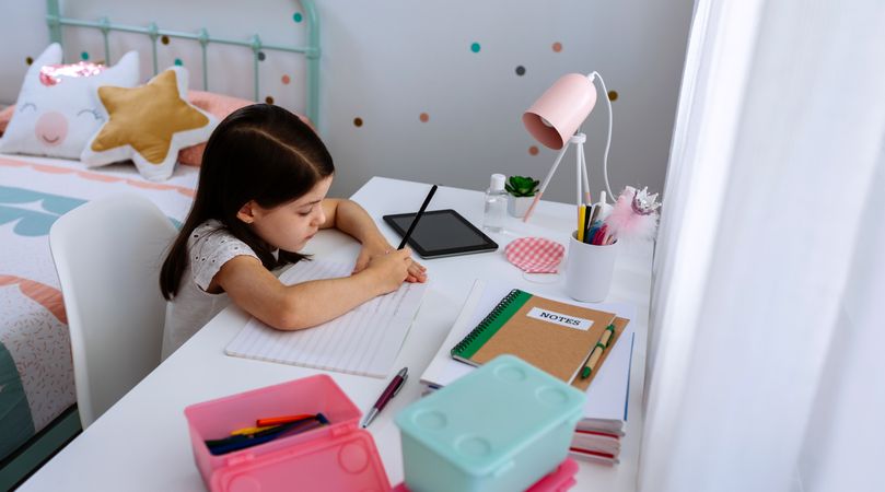Girl studying at home with mask on table
