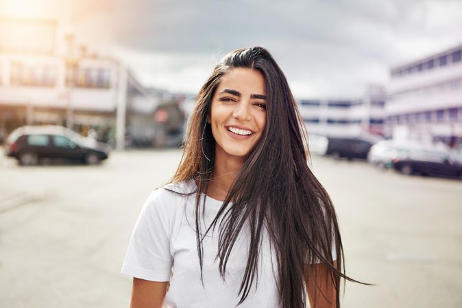 Happy brunette female on overcast day in parking lot