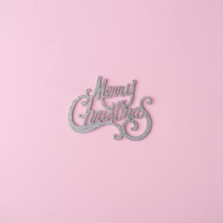 Merry Christmas glitter sign on pastel pink background