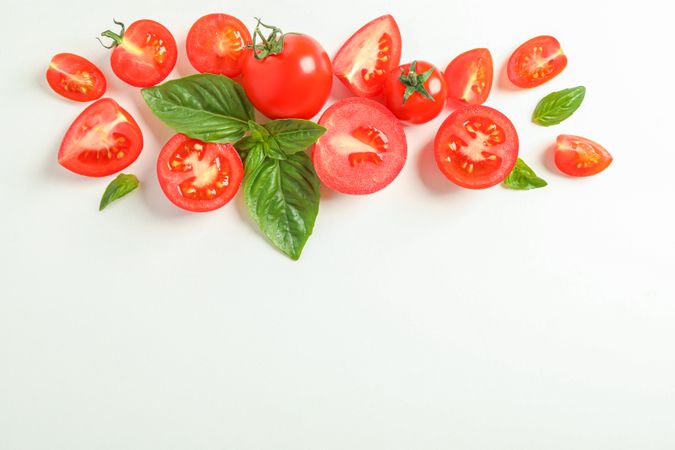Flat lay composition with fresh cherry tomatoes and basil on plain background, space for text. Ripe vegetables