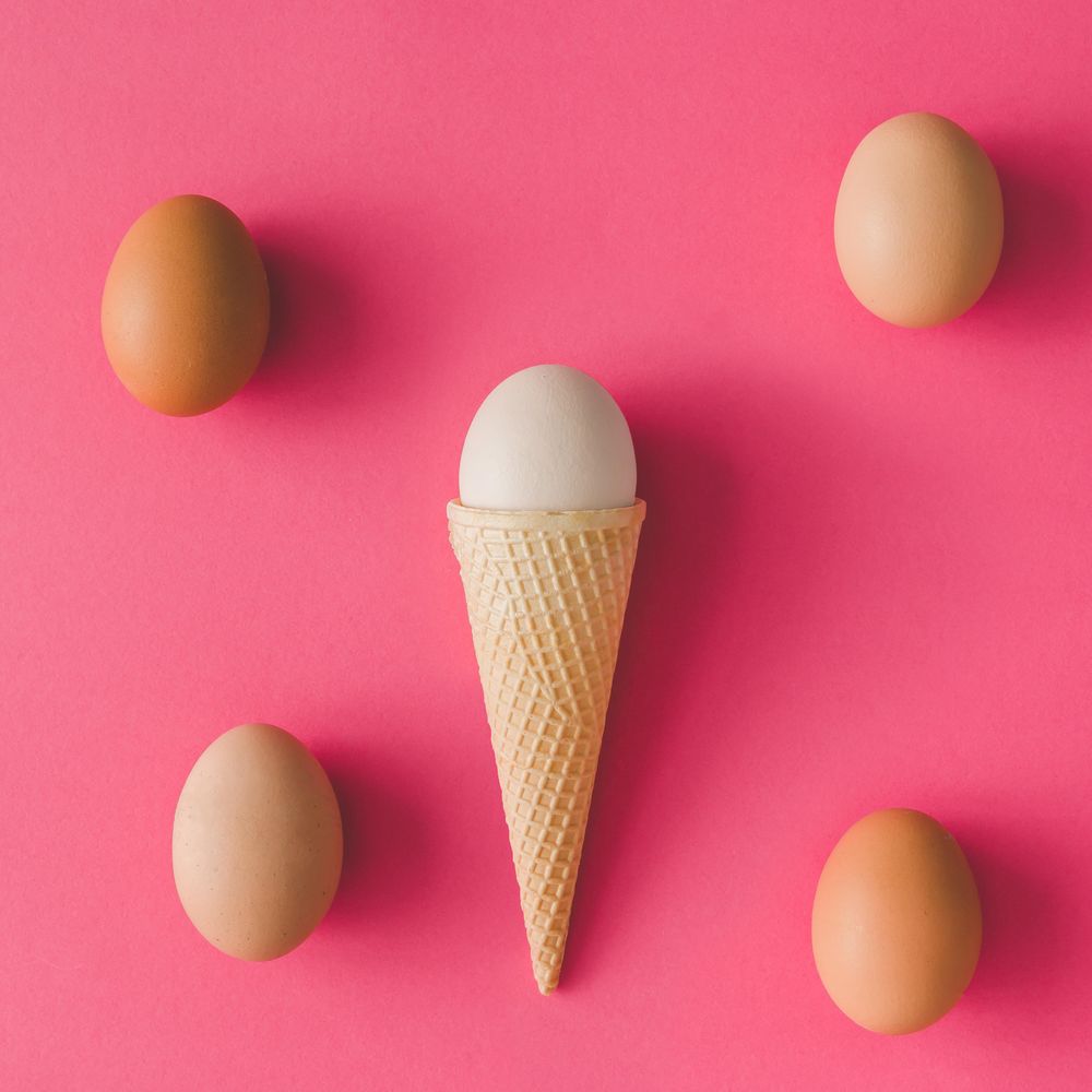 Ice cream cone with egg on pink background