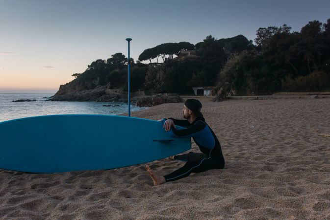 Man practicing paddle surfing with neoprene in a sunrise