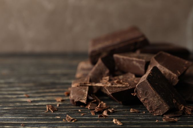Chocolate pieces on wooden background, close up