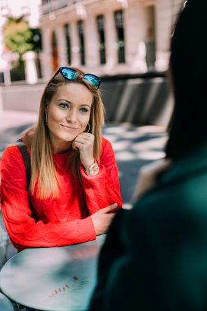 Young woman looking at friend in cafe