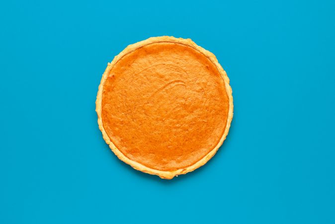 Whole pumpkin pie homemade, on a blue table