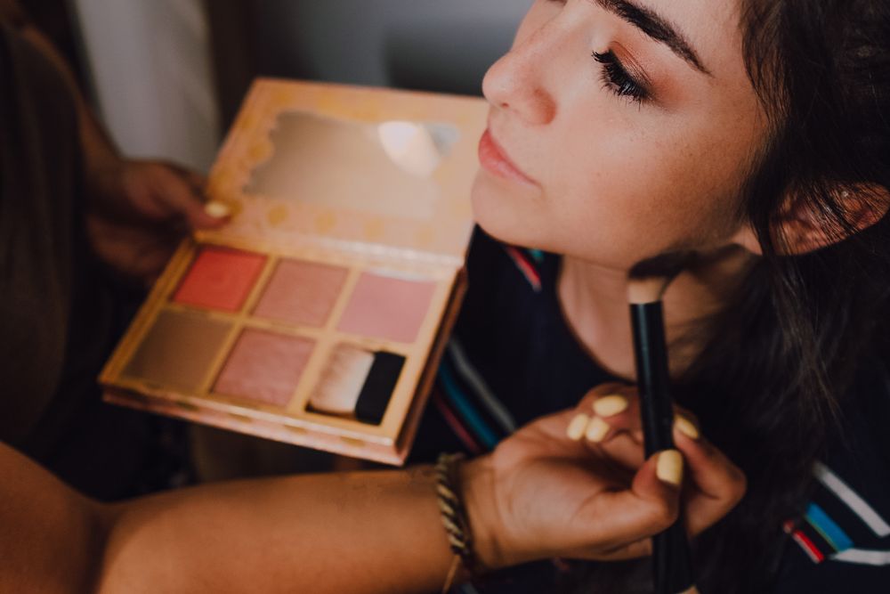 young female getting makeup in salon