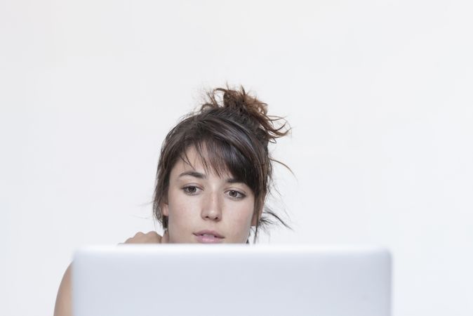 Female sitting at laptop screen, front view