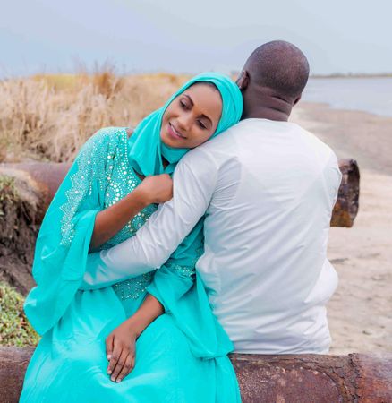 Man and a Muslim woman hugging each other at the beach