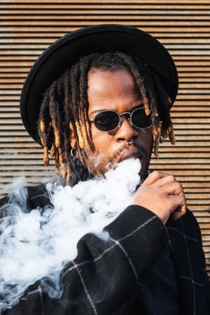 Trendy Black man in hat smoking