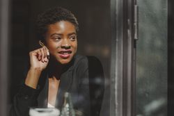 Smiling stylish Black woman in cafe
