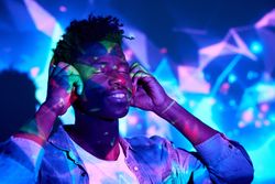 Smiling Black man listening to music in headphones in studio