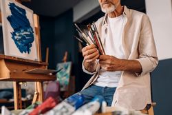 Male artist with his brushes with his work