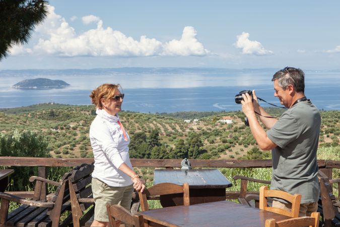 mature couple taking picture on cafe terrace