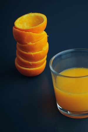 Stack of squeezed tangerines and a glass of juice